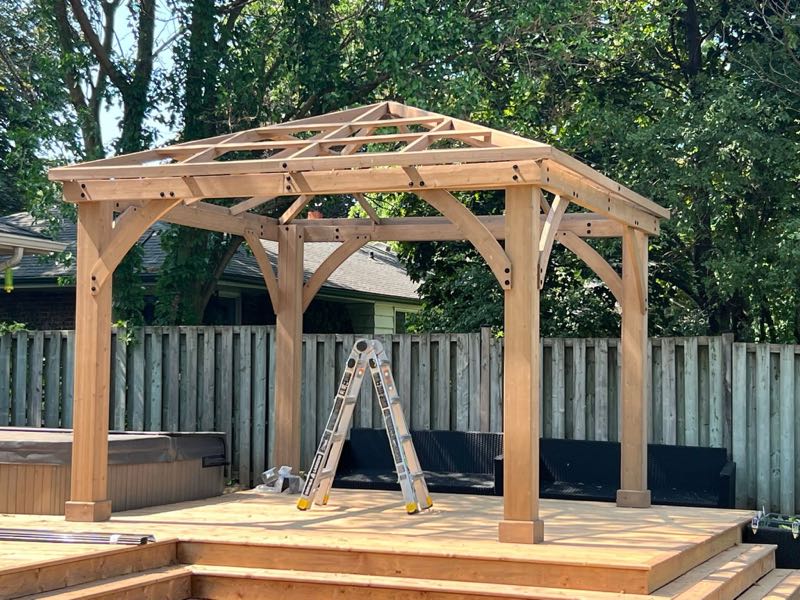 Wooden pergola with a peaked frame over a deck